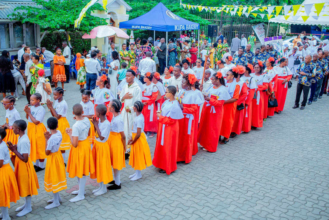 Maandamano ya waumini na kwaya ya watoto katika uwanja wa Kanisa